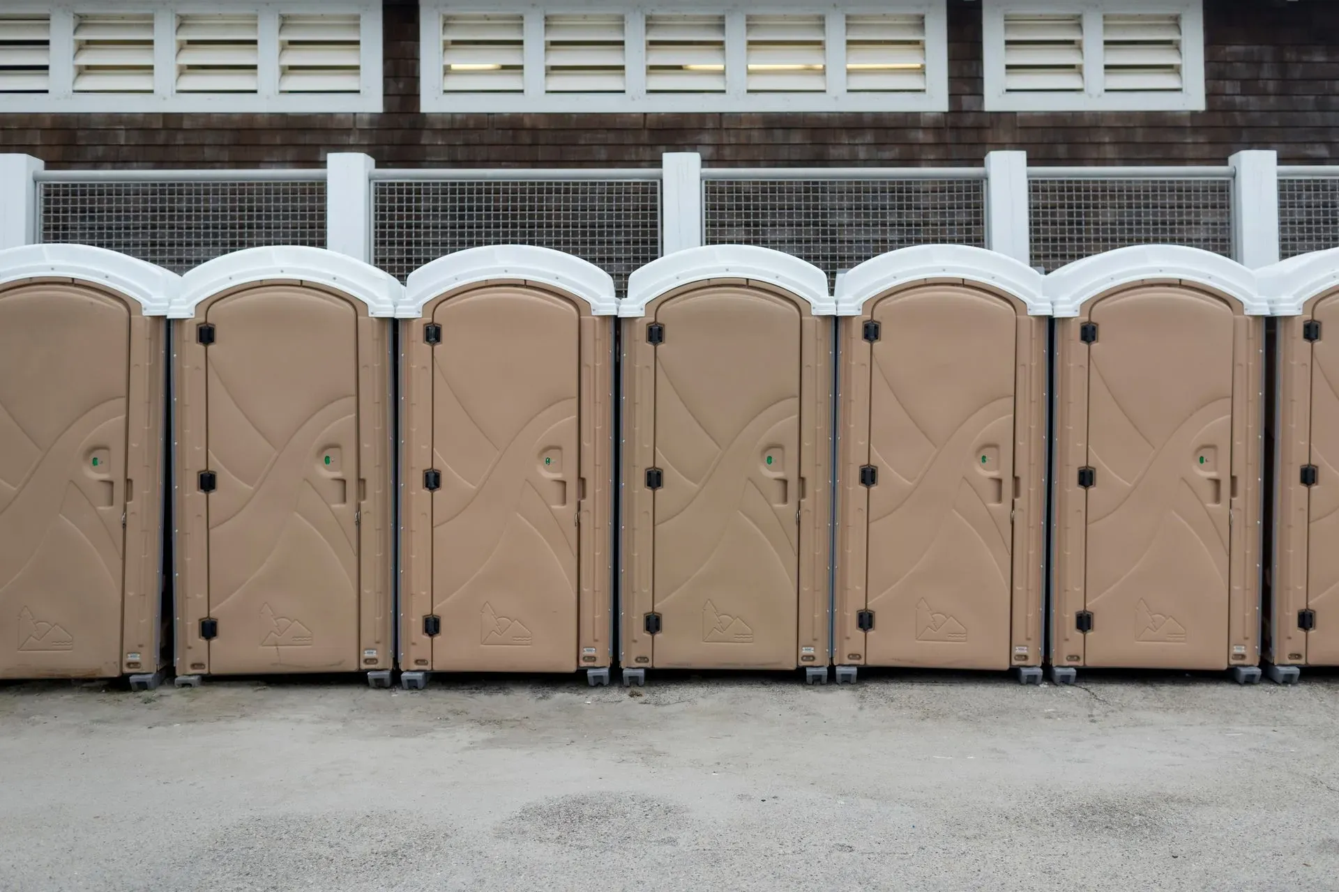 Parking lot at the beach with portable bathrooms.